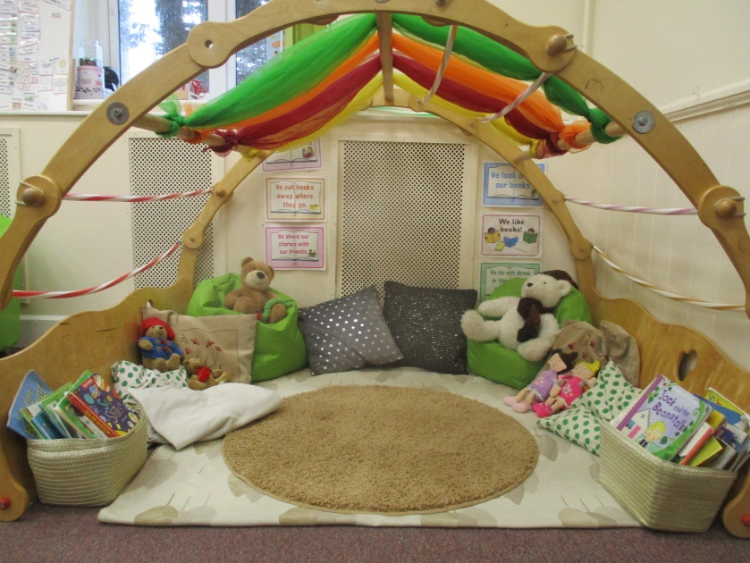 A larger picture of the reading area, showing baskets of books in addition to the cushions and toys.
